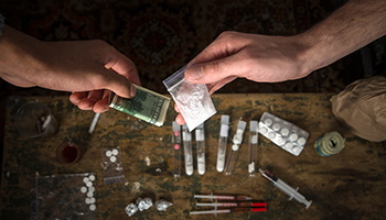 A close-up view of drugs and cash laid out on a table